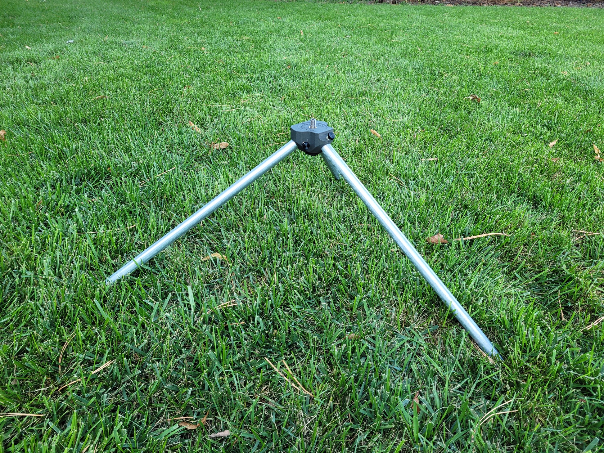 Tripod legs and center hub setup in grass
